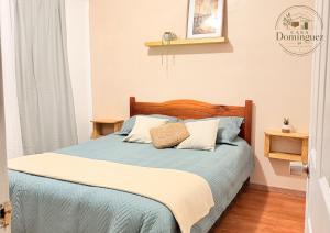 a bedroom with a bed with blue sheets and pillows at Taltal - Casa Dominguez in Taltal