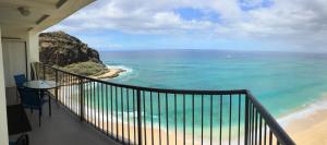 a balcony with a view of the beach and the ocean at Oceanfront Corner Unit , Hawaiian Princess in Waianae