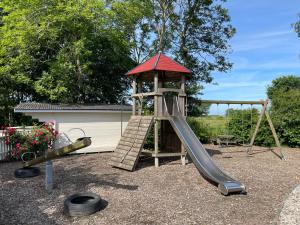 a playground with a slide and a play tower at Alpenstube Ockholm in Ockholm