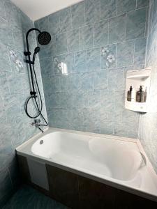 a bath tub in a bathroom with blue tiles at Casa Stefi in Copăceni +7 photos