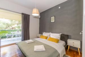 a bedroom with a bed with two towels on it at Varkiza Beach Summerhouse-Athens Riviera in Vari