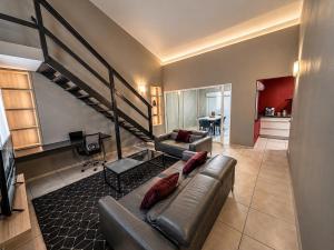 a living room with a couch and a staircase at L'Eskale Guyane in Montjoly +24 photos
