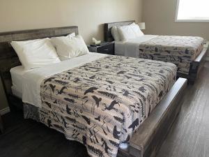 two beds in a hotel room with two beds at Timber Wolf Inn Motel in Nipigon