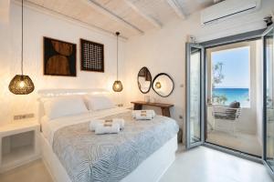 a bedroom with a bed with a view of the ocean at Blue Waves Suites & Apartments - To Kyma in Drios