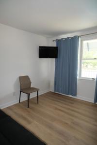 a empty room with a chair and a window at Cape Harbor Motor Inn in Cape May