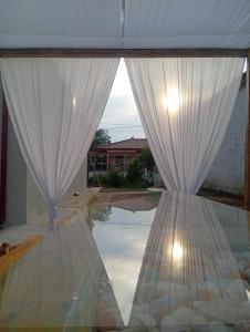 a view of a window with white curtains at Villa Harmony in Xanthi