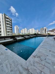 a swimming pool in a city with tall buildings at Ola del Mar in Gaira