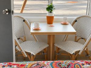 a table with two chairs and a table with two cups at Chelsea Motor Inn in Coffs Harbour
