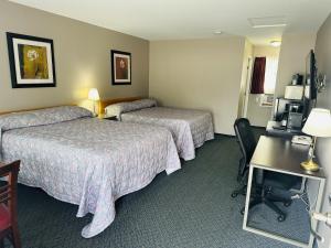 ein Hotelzimmer mit zwei Betten und einem Schreibtisch in der Unterkunft Heritage Inn in Hope