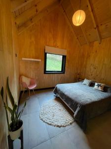 a bedroom with a bed and a potted plant at cabaña wooden in San Martín de los Andes