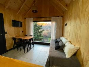 a room with a bed and a table and a window at cabaña wooden in San Martín de los Andes