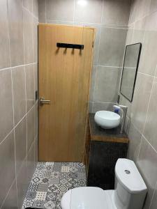 a bathroom with a toilet and a sink and a door at cabaña wooden in San Martín de los Andes +1 photo