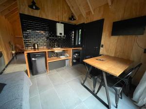 a kitchen with a wooden table and a table and chairs at cabaña wooden in San Martín de los Andes