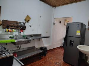 a kitchen with a sink and a refrigerator at Riveras Del Magdalena in Honda +2 photos