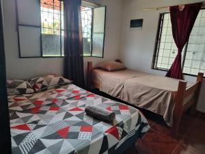 a room with two beds and two windows at Riveras Del Magdalena in Honda