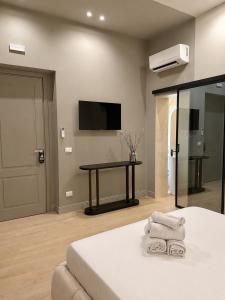 a bedroom with a bed and a table with towels at Xenia Suites Duomo in Reggio di Calabria