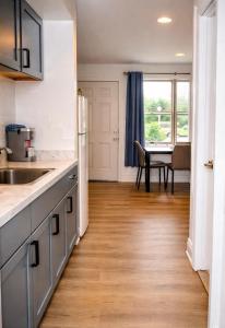 a kitchen with a sink and a table with a chair at Cape Harbor Motor Inn in Cape May