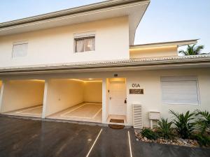 a white building with a parking lot in front of it at L'Eskale Guyane in Montjoly