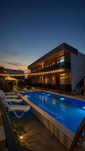 a hotel with a swimming pool in front of a building at Apollo Cottages Kaprovani in Urekis Sadguri