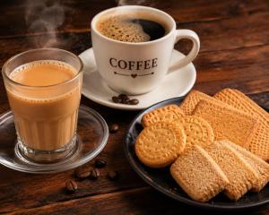 a cup of coffee and cookies and a cup of coffee at Hotel Montanaa Plaza Near Delhi Airport - Free Airport Pickup & Drop and Breakfast- Dinner complementary in New Delhi