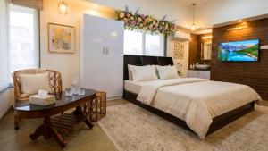 a bedroom with a bed and a table and a chair at De Majestic Grand Villa in Auroville