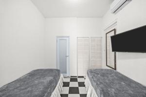 a bedroom with two beds and a flat screen tv at LISBD7D - JL Condado in San Juan