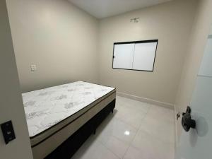 a small white room with a bed in it at Casa Cor in Aruanã