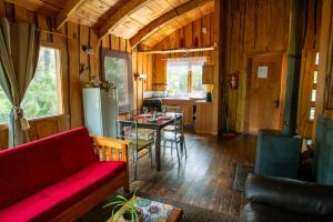 a living room with a red couch and a table at Patagonia Mawida in Neltume +45 photos