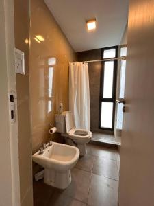 a bathroom with a toilet and a bidet and a sink at Emma in Villa Carlos Paz