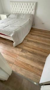a bedroom with a bed and a wooden floor at Emma in Villa Carlos Paz