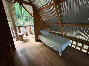 a bedroom with a bed in a room with a window at Entire Jungle Chalet Playa Ganadito in Drake