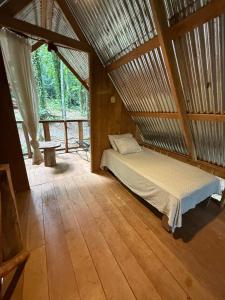 a bedroom with a bed in a wooden room at Entire Jungle Chalet Playa Ganadito in Drake