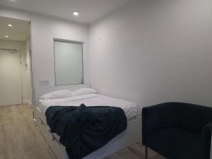 a white room with a bed and a chair at Kingsley at 1 on Albert in Cape Town