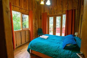 a bedroom with a bed in a log cabin at Patagonia Mawida in Neltume