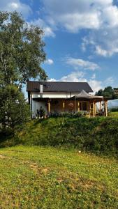 a house on a hill with a grassy field at Apaurin Lodge - Peacful Nature Escape near Bosnian Pyramids in Visoko