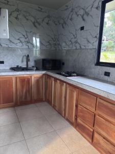 a kitchen with wooden cabinets and a sink and a window at Yalala Jacuzzi in Jabillos