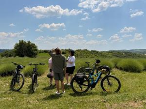 a group of people standing next to bikes in a field at Matea Slow Living Home Private Retreat in Čortanovci +29 photos