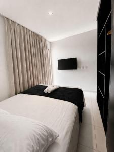 a bedroom with a bed and a tv on the wall at FLAT RESORT LUXO MALIA 215E- Porto de Galinhas - Muro Alto in Porto De Galinhas +85 photos