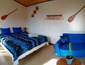 a bedroom with a blue bed and a blue chair at Fare Atihau Vairao in Matiti +39 photos