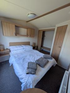 a bedroom with a large bed with towels on it at 69 Lighthouse View, Silver Sands Holiday Park in Lossiemouth