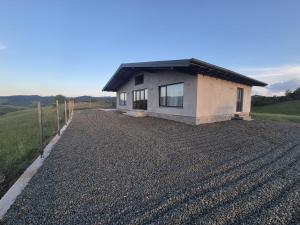 a house on top of a gravel driveway at Cindrel Chalet Jina in Jina