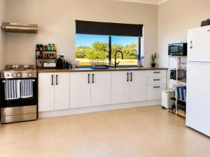 a kitchen with white cabinets and a window at Explorers Roost in Kalbarri