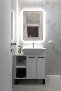 a bathroom with a white sink and a mirror at D'stay by Dastid in Golem +21 photos