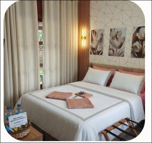 a bedroom with a bed with two towels on it at Casa com piscina e área gourmet próximo à praia com quarto suíte privativo in Saquarema