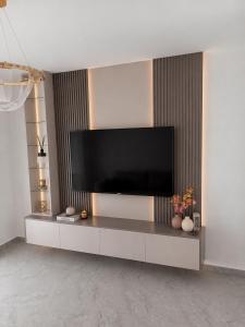 a living room with a flat screen tv on a wall at Villa Deromano in Šušanj