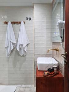a bathroom with a sink and a shower with towels at Dar Al Massir in Chefchaouen +20 photos