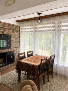 a dining room with a wooden table and chairs at Apaurin Lodge - Peacful Nature Escape near Bosnian Pyramids in Visoko