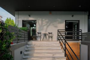 a staircase leading up to a house with chairs at Anemos Suites Loutraki in Loutraki