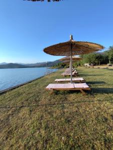 a group of chairs with an umbrella on a beach at Camping Principata in Brungaj