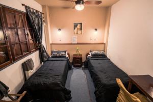 two beds in a room with a ceiling fan at Hostel & Spa Mediterránea in Córdoba